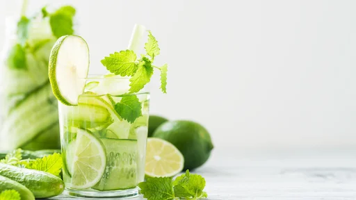 Refreshing drink with cucumber, lime, mint. Detox concept. White rustic table. Copy space