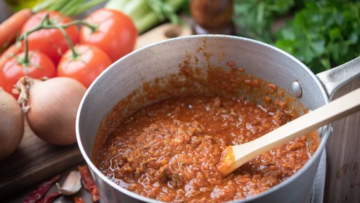 bolognaise sauce in pot with ingredients background