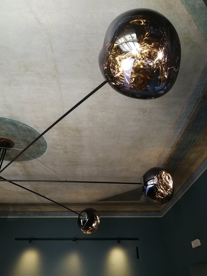 Luči oblikovalca Toma Dixona so zvezali v lestenec neslutenih razsežnosti, ki je skoraj tak, kot bi na stropu modrega salona obvisel kos kakega sputnika.