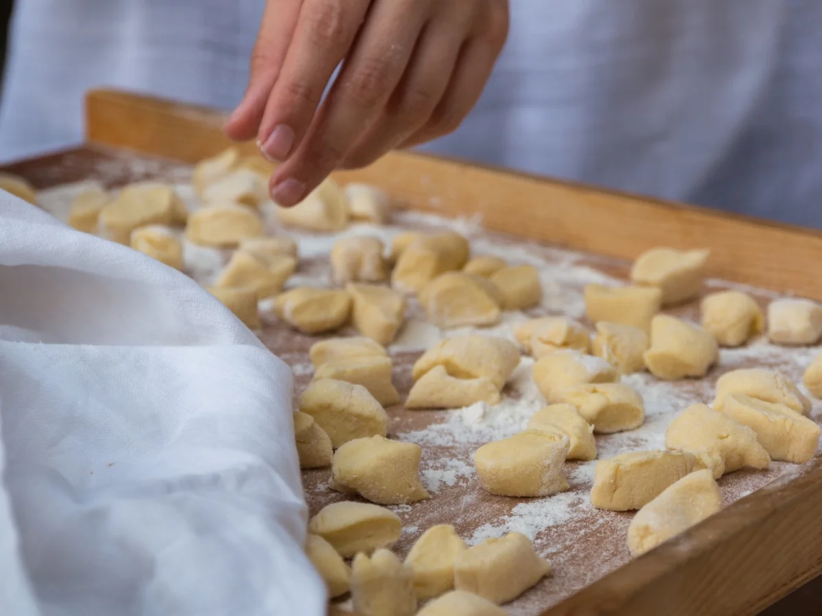 Small Dumplings on Wooden Board with Flour: Italian Gnocchi Pasta