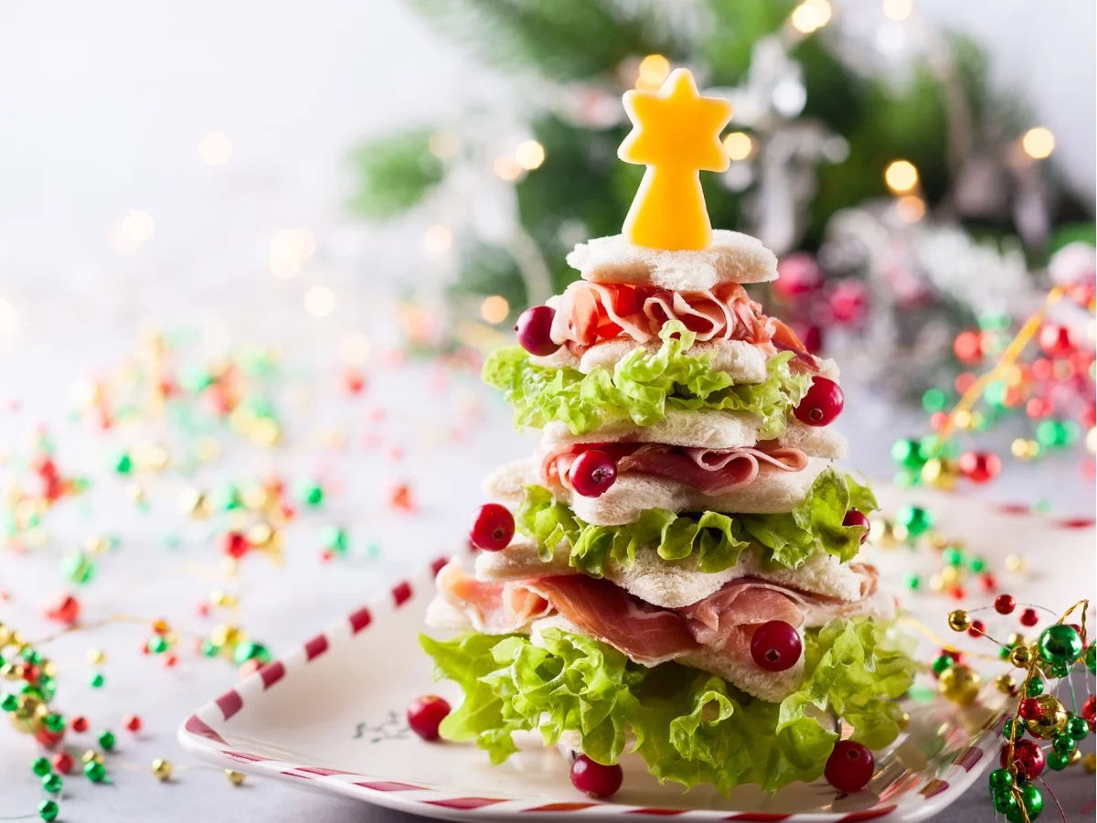 Christmas tree from toasted bread, lettuce, ham and cheese. Festive idea for Christmas or New Year dinner.