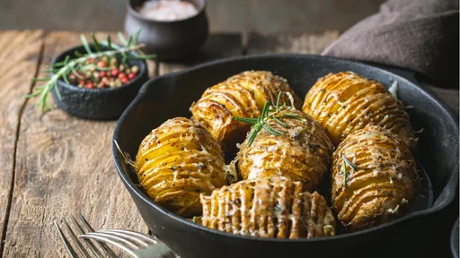 Baked hasselback potatoes with cheese, garlic and greens