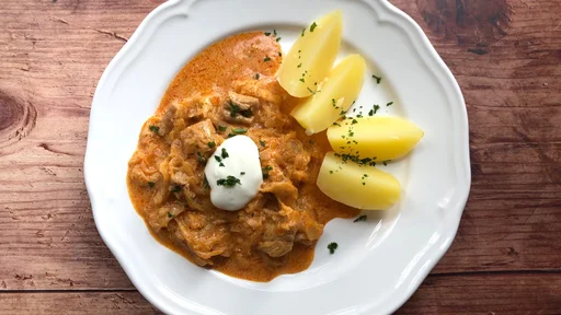 Hungarian Szegedin or Szeged Goulash with sour cabbage and boiled potatoes. Meat in which is cut into cubes, sour cream, onions, garlic, paprika and laurel are the ingredients.