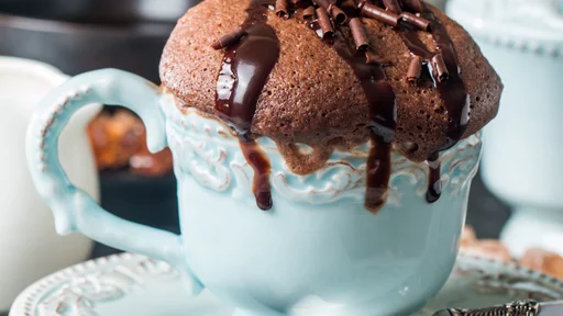 Chocolate souffle with chocolate glaze in a cup on grey background