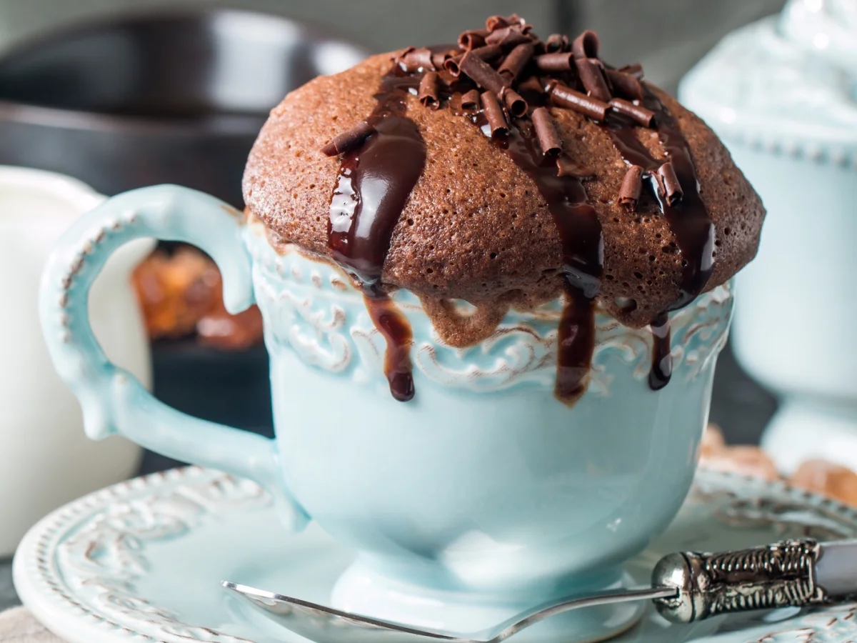 Chocolate souffle with chocolate glaze in a cup on grey background