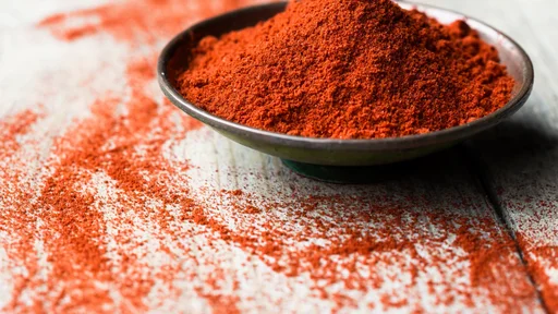 Ground Paprika in a bowl on wooden table