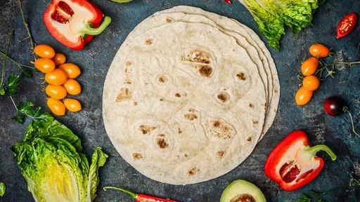 Ingredients for tacos or burrito making. Fresh organic vegetables and tortillas on rustic background, top view, place for text (Ingredients for tacos or burrito making. Fresh organic vegetables and tortillas on rustic background, top view, place for