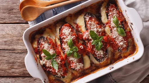Italian eggplant baked with mozzarella in tomato sauce close up in baking dish. horizontal view from above