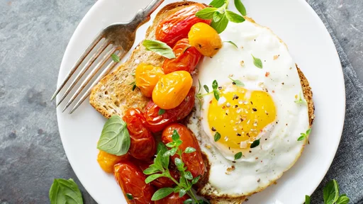 Multigrain toast with fried egg, fresh herbs and roasted tomatoes