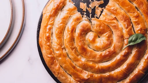 Filo Spinach and Feta Twist Pie in the iron pan after oven. Authentic Greek bakery. With spinach, mizithra and feta cheeses. (Filo Spinach and Feta Twist Pie in the iron pan after oven. Authentic Greek bakery. With spinach, mizithra and feta cheeses.,