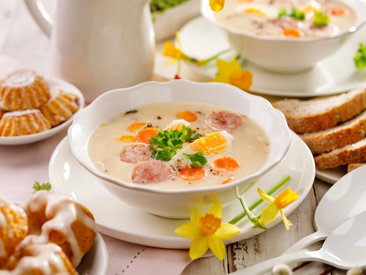 White borscht, polish Easter soup with the addition of white sausage and a hard boiled egg in a ceramic bowl. Traditional Easter dish in Poland