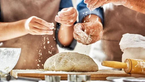 Close up view of bakers are working. Homemade bread. Hands preparing dough on wooden table.