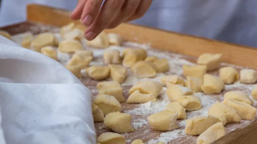 Small Dumplings on Wooden Board with Flour: Italian Gnocchi Pasta