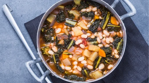 Vegetables soup with legumes, vegetables, kale directly above.Traditional tuscany soup, ribollita.