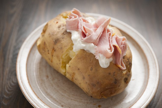 Pečen krompir v oblicah lahko nadevate tudi s skuto, kislo smetano in narezano šunko.