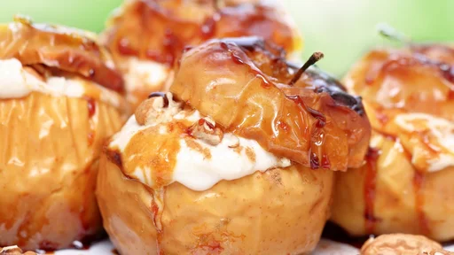 Closeup photo of a tasty baked apples stuffed with cream honey and nuts, healthy nutrition, delicious sweet food, gorgeous fruit dessert flavored with cinnamon (Closeup photo of a tasty baked apples stuffed with cream honey and nuts, healthy nutritio