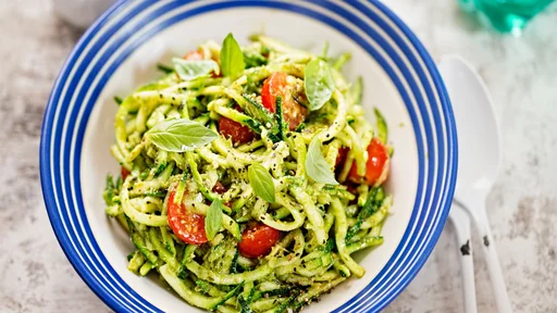 Spiralled courgette spaghetti with green pesto and cherry tomatoes