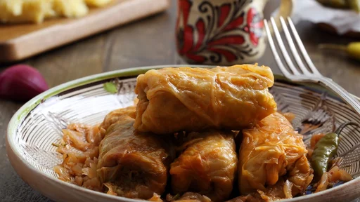 Stuffed cabbage rolls with rice in tomato sauce on rustic table background