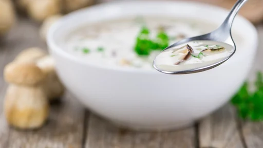 Homemade Porcini Soup on vintage background selective focus; close-up shot