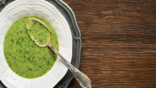 Fresh green soup on wooden background overhead shoot.