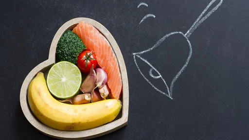 Time for health heart abstract diet food concept on blackboard with bell closeup