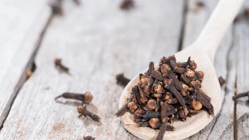 Small portion of Cloves on a wooden spoon (close-up shot)