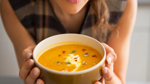 Closeup on young woman enjoying pumpkin soup
