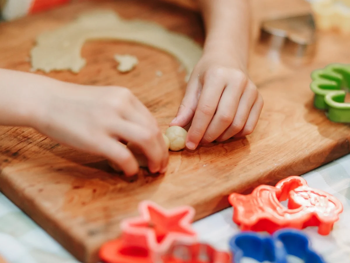 Child mixing flour in the kitchen, making dough.