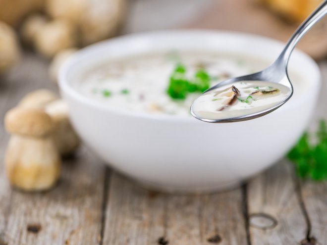 Homemade Porcini Soup on vintage background selective focus; close-up shot