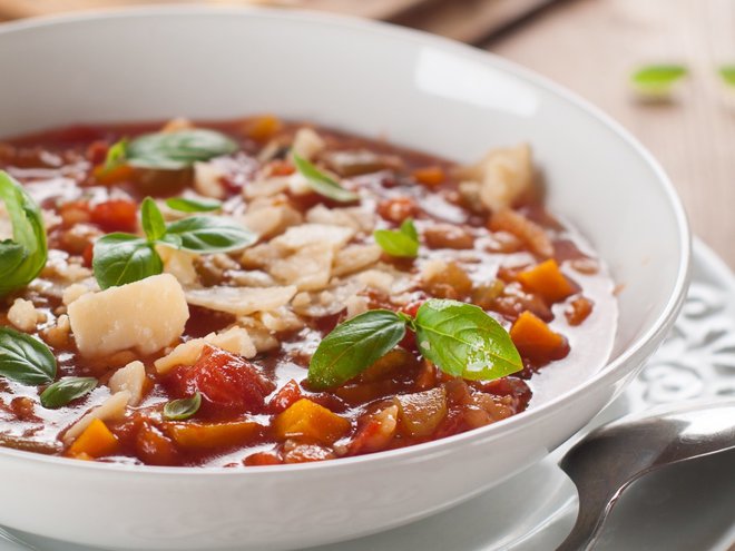 Minestrone soup with cheese and basil, selective focus