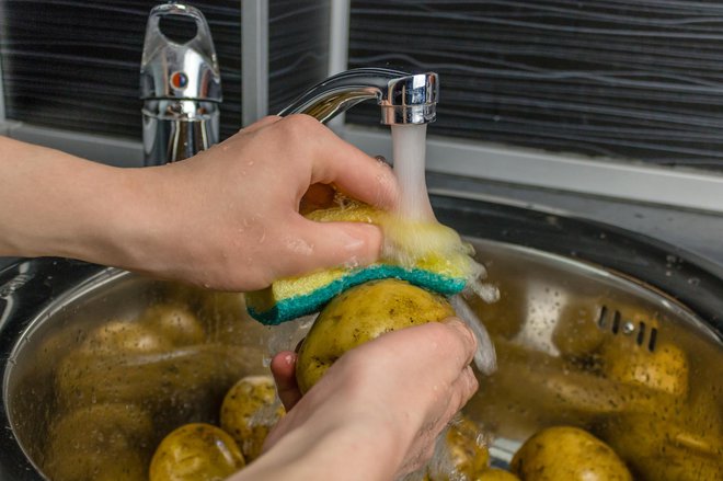 Mladi krompir dobro operemo, po potrebi zdrgnemo s ščetko ali gobico. FOTO: Dmitry Shundeev/Getty Images