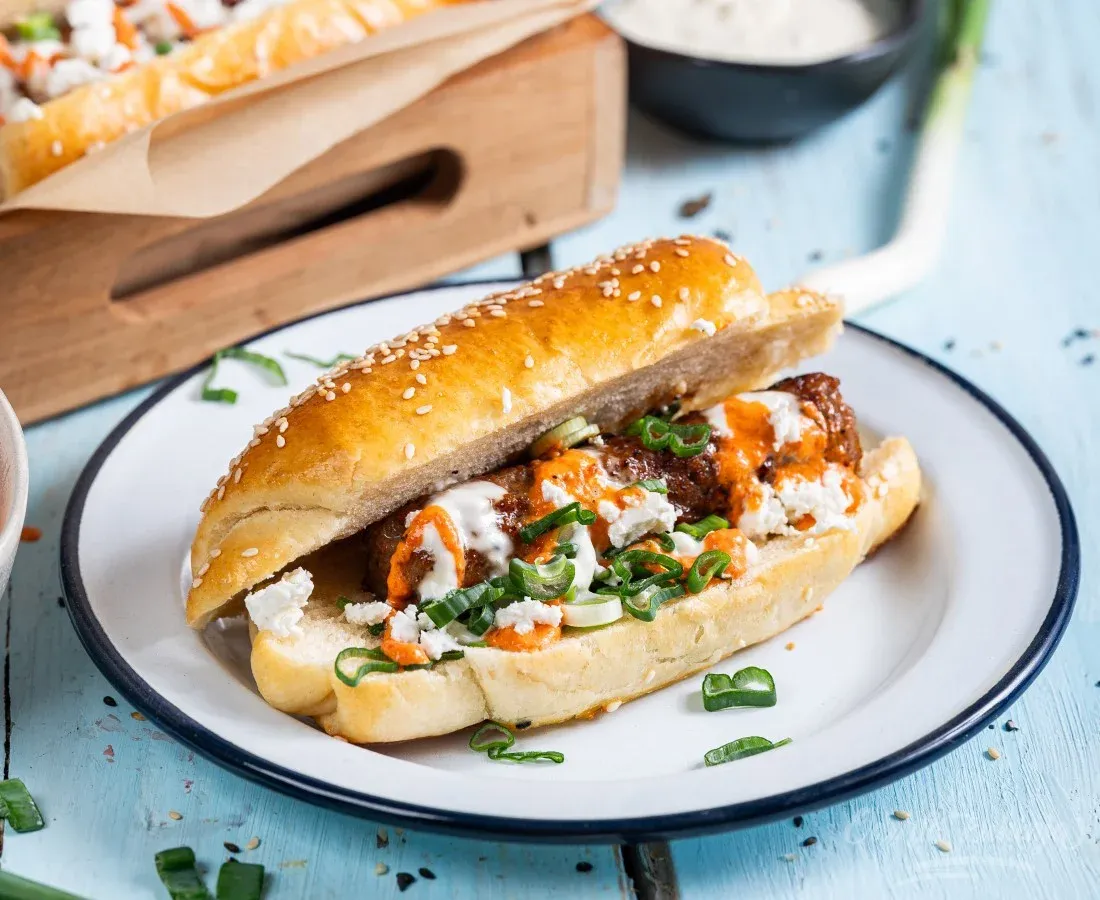 Hot dog s čevapčiči z omakama iz kajmaka in pečene paprike (Midva kuhava)